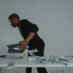 A person quickly gathers cash into a briefcase, conveying a sense of urgency and action.